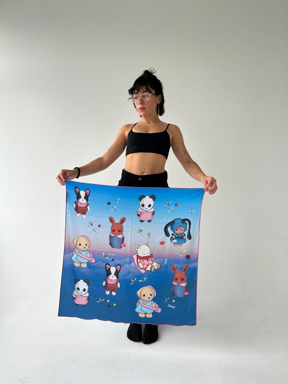 Model posing with a large silk scarf adorned with cute animal characters like a dog, panda, and rabbit, set against a sky-themed background. A fun and stylish accessory, great for those who enjoy animal-themed fashion or handmade scarves.