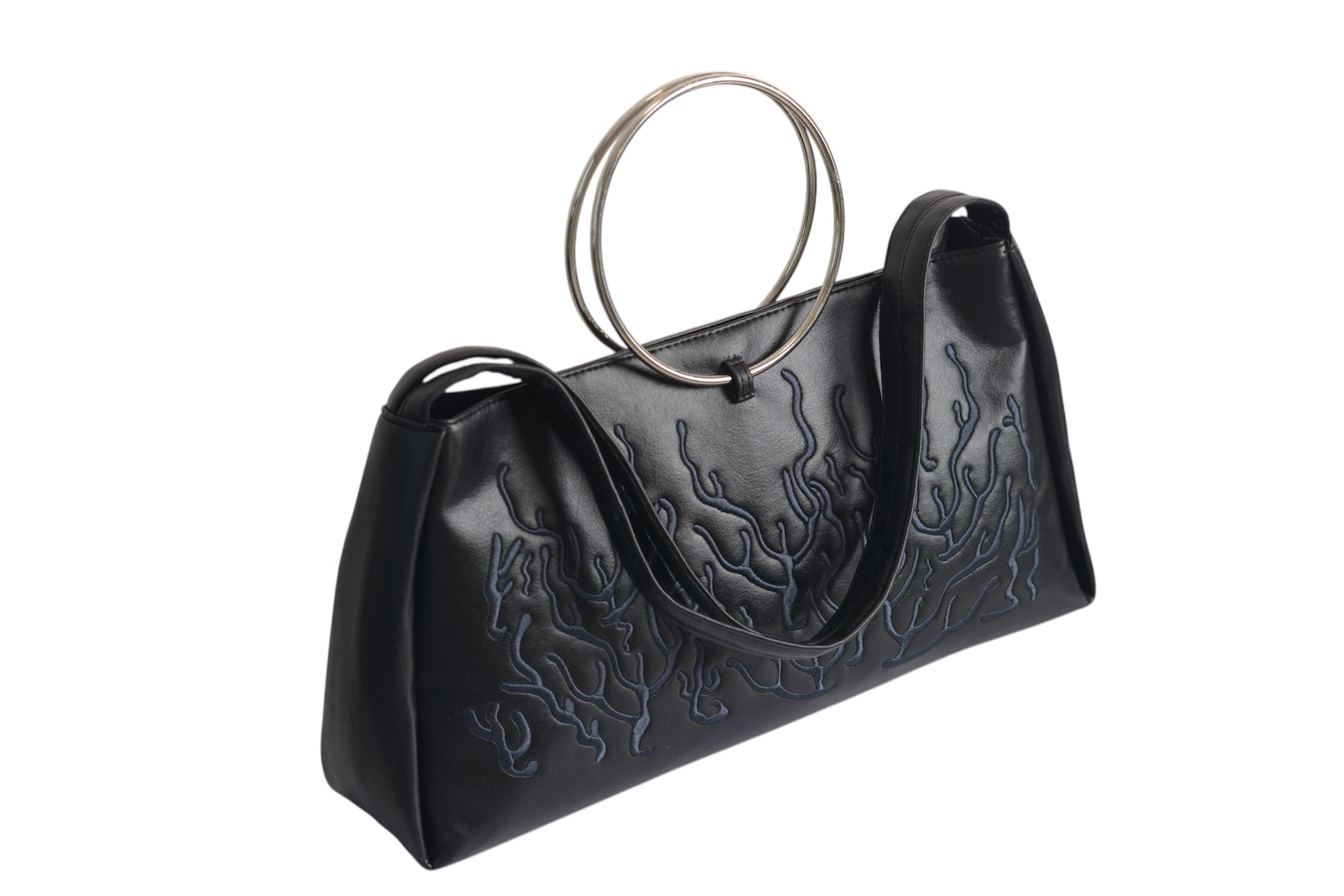 Black bag features a circular and wavy metallic embellishment on the front. Made from faux leather material with rings up