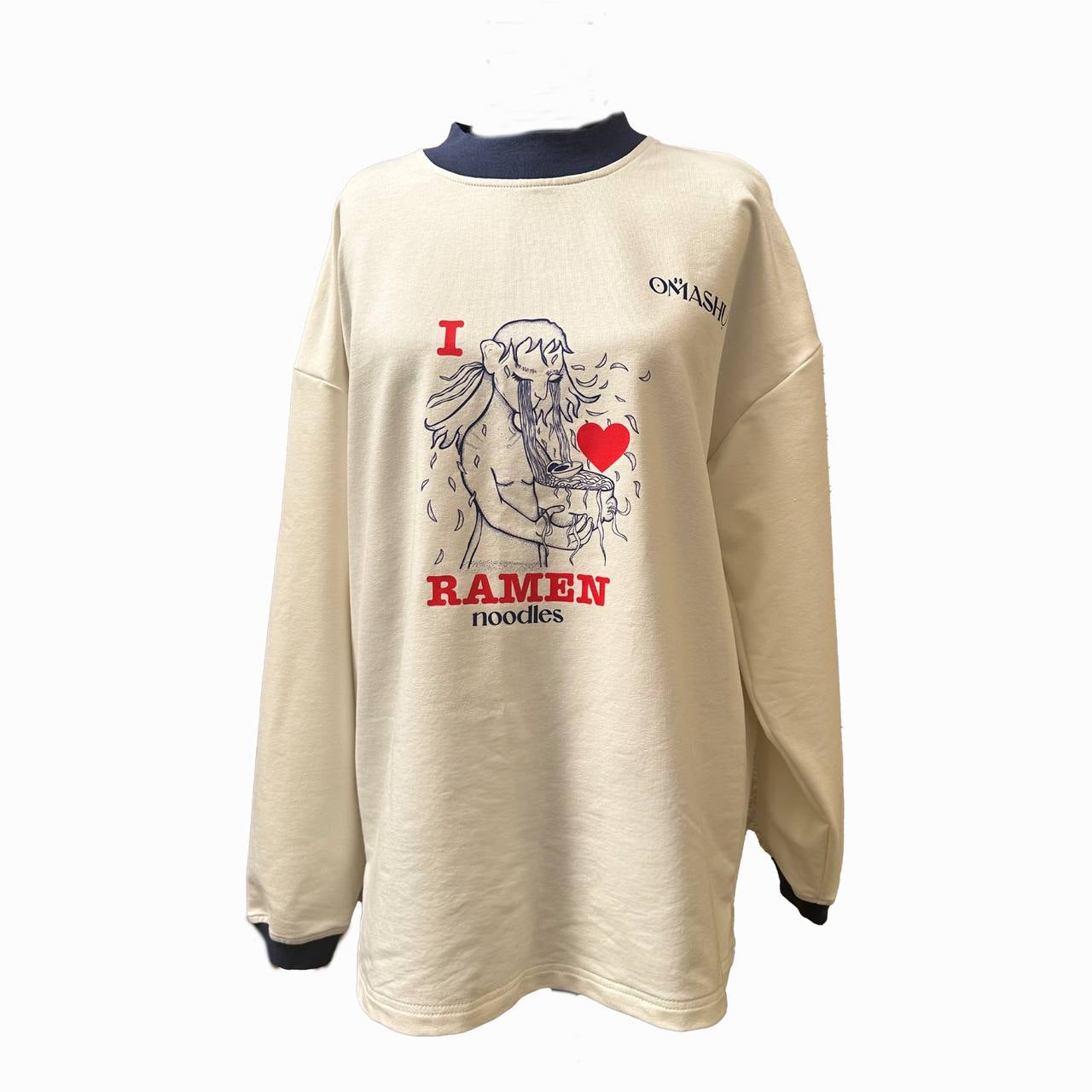 A cream-colored oversized sweatshirt featuring an illustration of a dog enjoying a bowl of ramen noodles. The design includes the text "I ❤️ RAMEN noodles" in bold red and black lettering. The dog appears to be savoring the noodles, with steam rising from the bowl. The word "OMASHU" is printed on the upper left of the sweatshirt. The overall style is playful and cozy.