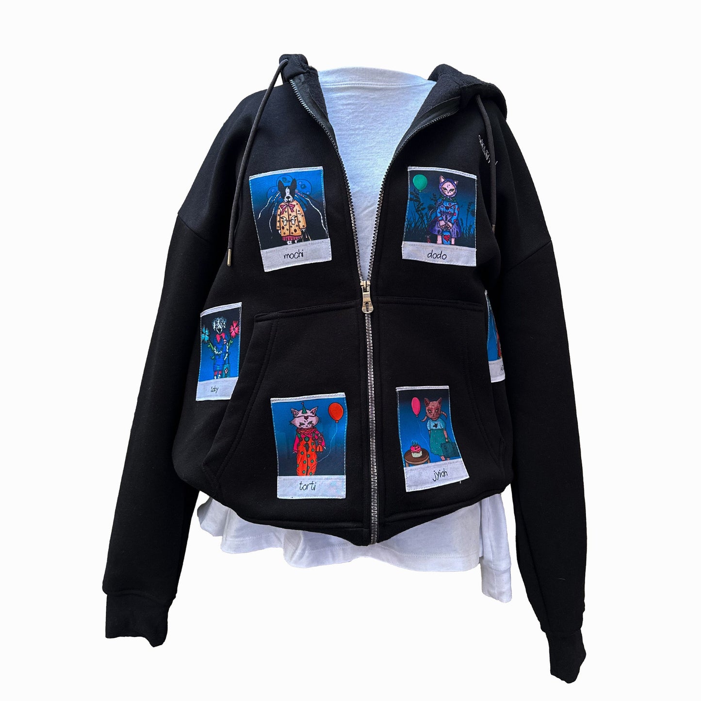 A black zip-up hoodie displayed on a mannequin, featuring six colorful Polaroid-style patches of animal characters. The characters include "Mochi," "Dodo," "Torti," "Jiyah," "Toby," and another on the back. The hoodie is shown with the zipper open, revealing a white inner layer underneath.