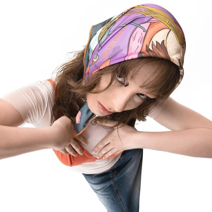 girl with eyeliner wearing OMASHU scarf on her head while wering tranparent white tshirt and orange bikini.