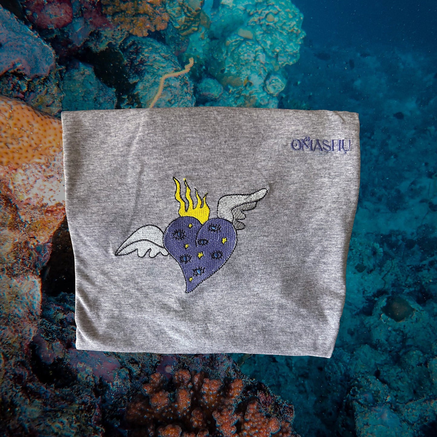 a folded t-shirt with gray heart and brand name Omashu