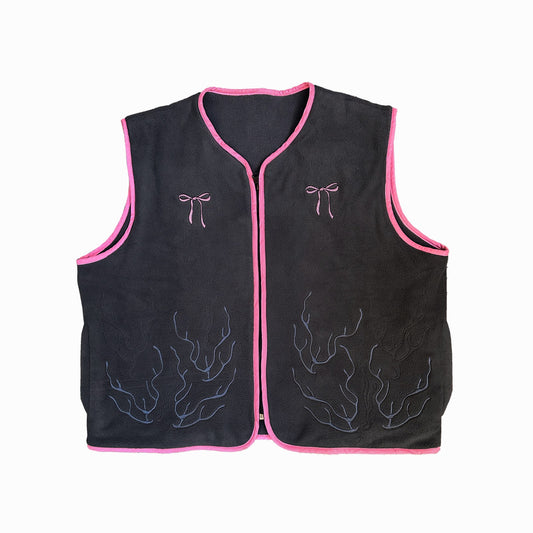 A gray vest with pink outlines, decorative stitching, and bows.