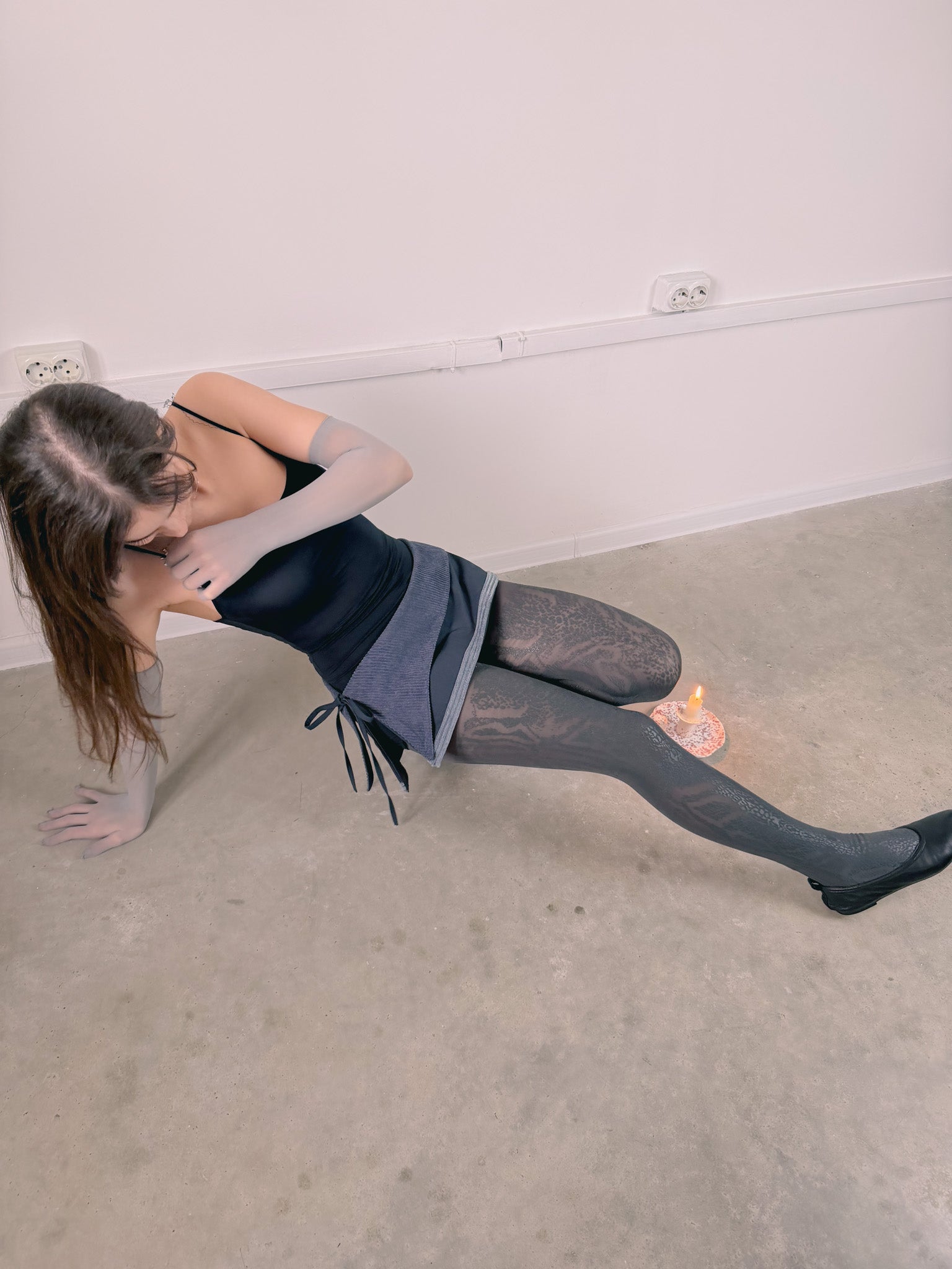 Person stretching on a carpeted floor with a white wall background