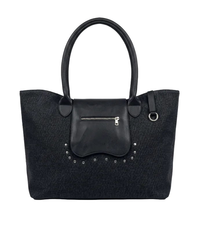 A black textured tote bag with a smooth black leather front flap pocket, silver-tone zipper, and decorative silver studs, shown against a light gray background.