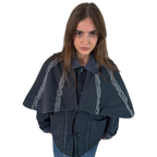 Person wearing a dark blue cape with chain details on a white background