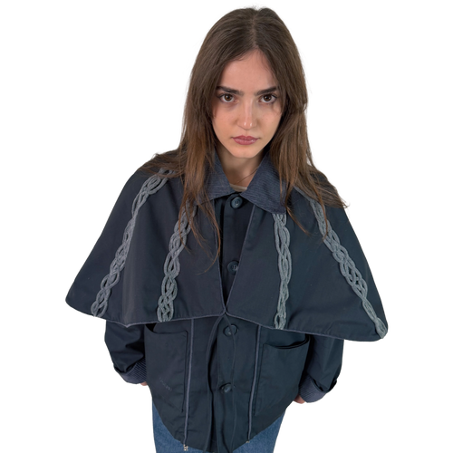 Person wearing a dark blue cape with chain details on a white background