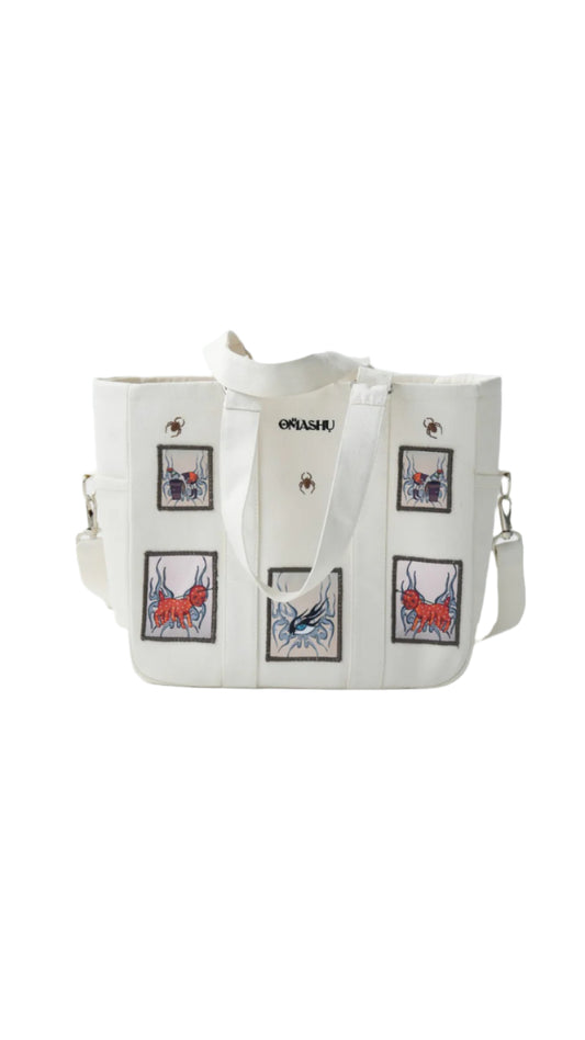 Omashu white tote bag with embroidered patches and laptop divider, featuring bold, street-style graphics.