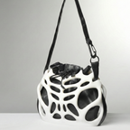 Black and white geometric-patterned bag on a gray background