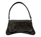 A black leather shoulder bag with a curved top handle and a large embossed monogram logo on the front flap, shown against a plain white background.