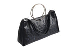Black bag features a circular and wavy metallic embellishment on the front. Made from faux leather material with rings up
