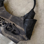Black handbag on a textured stone surface