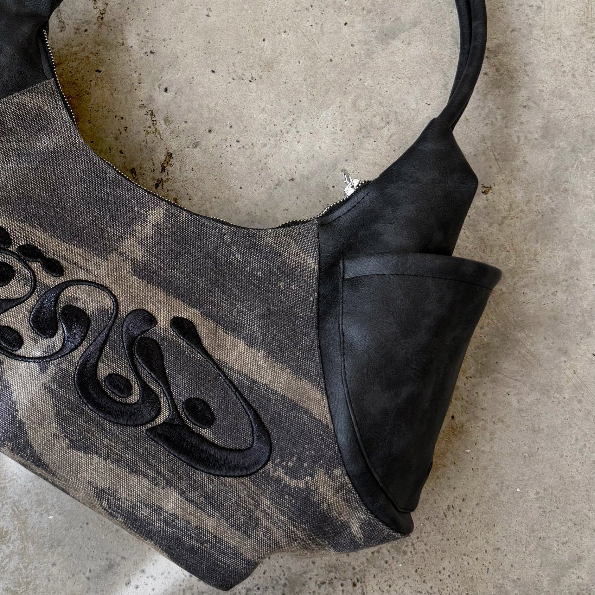 Black handbag on a textured stone surface