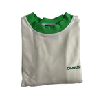 White t-shirt with a green collar and a small green text on the bottom right corner that reads ‘OMASHU’. The t-shirt is neatly folded and has a tag on the inside of the collar.