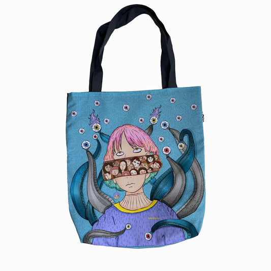 A blue tote bag with a colorful illustration of a girl with pink hair and a purple shirt. The girl is wearing a pair of goggles with octopus tentacles coming out of them. The tentacles are decorated with colorful jewels and pearls. The background of the illustration is a light blue color with bubbles and more jewels scattered around. The bag has black handles and a white interior.