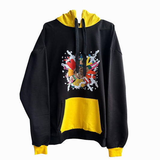 A black and yellow hoodie with a colorful graphic on the front. The hoodie has a black body and yellow sleeves and hood. The graphic on the front is a colorful explosion of flowers, leaves, and paint splatters. The graphic also includes a hand holding a paintbrush and a bird. The hoodie has a drawstring hood and a front pouch pocket. The background is white.